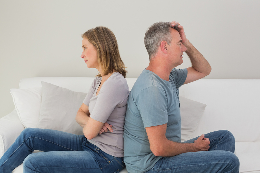 Unhappy couple not talking after an argument in the living room at home